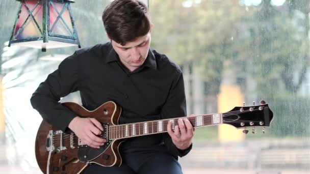 Talentoso Guitarrista Uma Camisa Preta Toca Guitarra Café Frente Janela — Vídeo de Stock