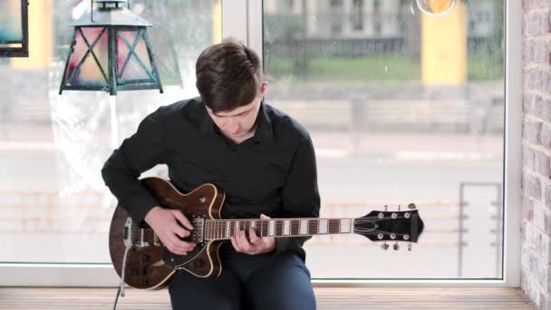Anak Muda Melakukan Jazz Blues Musik Pada Gitar Duduk Jendela — Stok Video