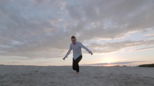 Όμορφος Χορευτής Εκτελεί Μια Ελεύθερη Χορευτική Σύνθεση Στην Αμμώδη Παραλία — Αρχείο Βίντεο