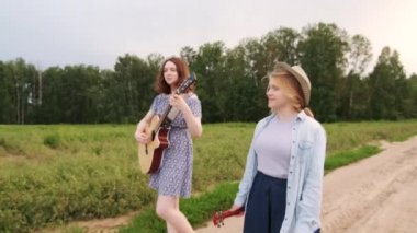 İki genç kadın bir yaz akşamında gün batımında bir buğday tarlası boyunca yürür ve şarkı söyler. Gitar ve gitar. Gimbal atışı.