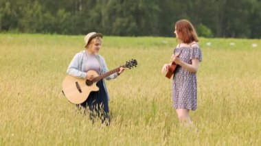 İki güzel kadın gitar ve ukulele ile country müzik çalıyorlar. Bir yaz akşamında gün batımında buğday tarlası