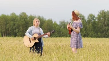 İki güzel kadın gitar ve ukulele ile country müzik çalıyorlar. Bir yaz akşamında gün batımında buğday tarlası