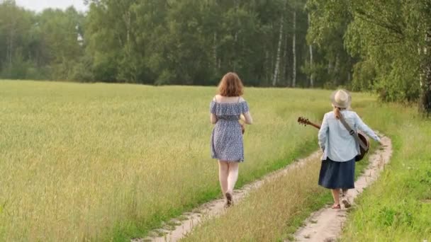 Two Young Girls Guitar Ukulele Walking Road Wheat Field Sunset — Stock Video