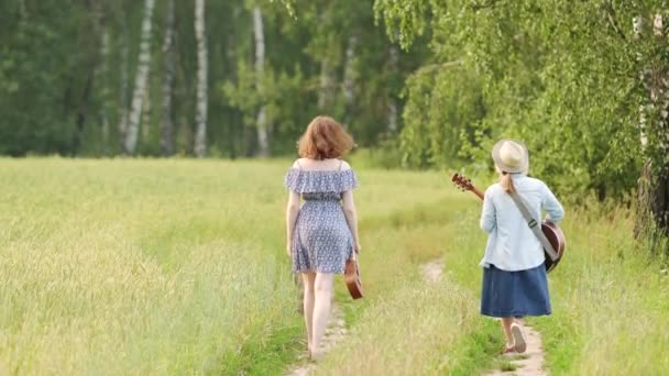 Two Young Girls Guitar Ukulele Walking Road Wheat Field Sunset — Stock Video