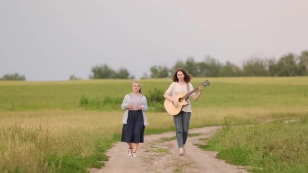 Duas Meninas Bonitas Jovens Caminham Cantam Longo Campo Trigo Pôr — Vídeo de Stock