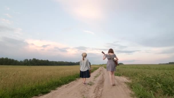 Zwei Junge Mädchen Mit Gitarre Und Ukulele Gehen Einem Sommerabend — Stockvideo
