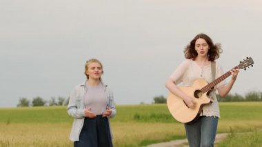 İki güzel kadın bir yaz akşamında gün batımında bir buğday tarlasında yürür ve şarkı söyler. Kız gitara eşlik ediyor. Yavaş çekim görüntüleri