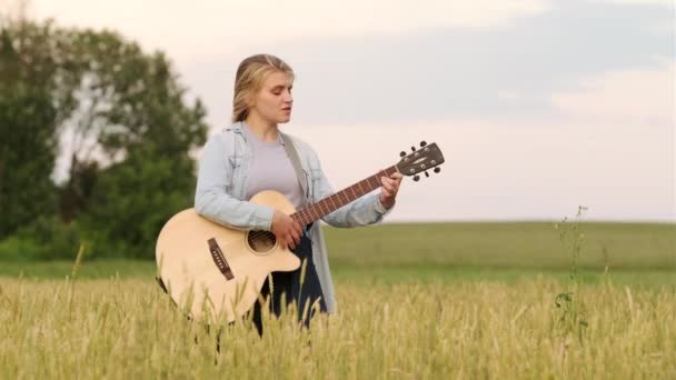 Jovem Cantando Tocando Guitarra Campo Trigo Pôr Sol Uma Bela — Vídeo de Stock