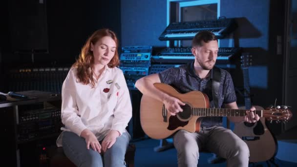 Duet Van Een Gitarist Een Roodharige Zanger Een Muziekstudio Middellange — Stockvideo