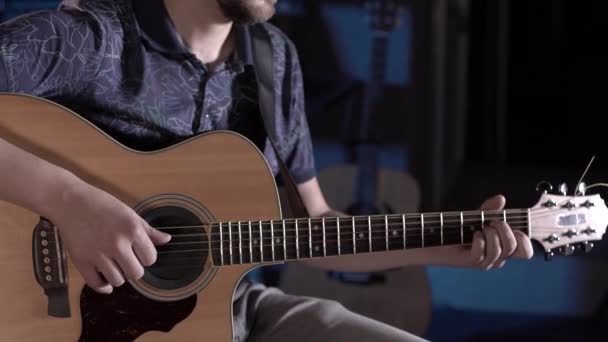 一个留着胡子的男人在一个音乐工作室里弹吉他 吉他弦和颈的闭合 — 图库视频影像