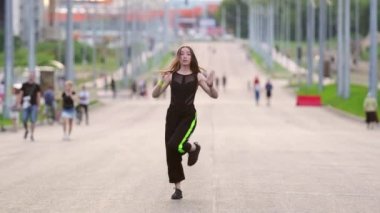 Geniş şehir hip hop 'unda dans eden uzun saçlı genç ve güzel bir kadın. Şehirde serbest dans yapan bir şehir. Gençlik alt kültürü. Yavaş çekim