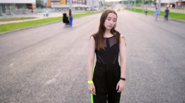 Geniş şehir hip hop 'unda dans eden uzun saçlı genç ve güzel bir kadın. Şehirde serbest dans yapan bir şehir. Gençlik alt kültürü. Ağır çekim. El kamerası.