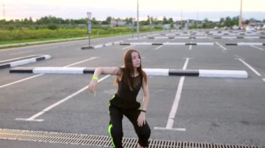 Genç ve güzel bir dansçı. Uzun saçlı. Modern gençlik dans ediyor. Ağır çekim. El kamerası.