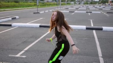 Genç ve güzel bir dansçı. Uzun saçlı. Modern gençlik dans ediyor. Ağır çekim. El kamerası.