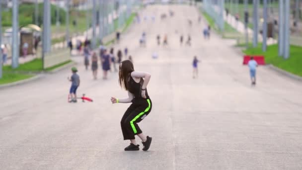Девушка Танцует Улице Заднем Плане Видны Размытые Силуэты Людей Хип — стоковое видео