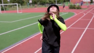 Hip hop koreografisi ve stadyum koşu bandında break dans yapan genç bir kadının videosu. Gençlik alt kültürü. Yavaş çekim
