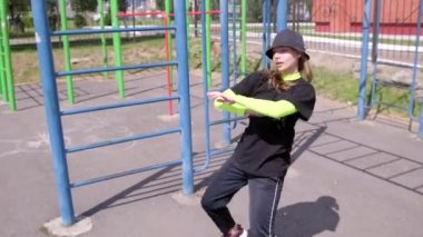 Eşofmanlı genç bir kız dansçı ve sokak dansı yapan bir şapka, Sportsground 'da hip hop yapan. Modern gençlik dansının olağanüstü unsurlarını sergiliyor. Yavaş çekim