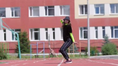 Eşofmanlı genç bir kız dansçı ve sokak dansı yapan bir şapka, Sportsground 'da hip hop yapan. Modern gençlik dansının olağanüstü unsurlarını sergiliyor. Yavaş çekim