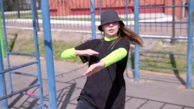 Eşofmanlı genç bir kız dansçı ve sokak dansı yapan bir şapka, Sportsground 'da hip hop yapan. Modern gençlik dansının olağanüstü unsurlarını sergiliyor. Yavaş çekim