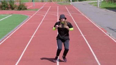 Hip hop koreografisi ve stadyum koşu bandında break dans yapan genç bir kadının videosu. Gençlik alt kültürü. Yavaş çekim