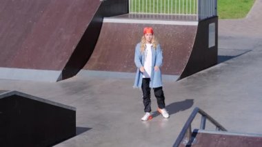 Olağanüstü genç kız kaykay alanında modern gençlik dansı yapıyor. Yavaş çekim