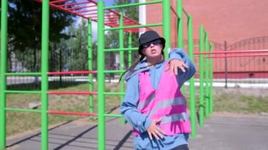 Aktif genç bir kadının hip hop koreografisi ve spor sahasında break dans yaptığı bir video. Yavaş çekim