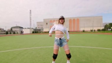 Şehir stadyumunda uzun saçlı muhteşem genç bayan twerk dansı yapıyor. Yavaş çekim