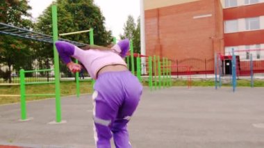 Güzel, genç esmer, uzun saçlı, spor sahasında popo dansı yapan. Yavaş çekim