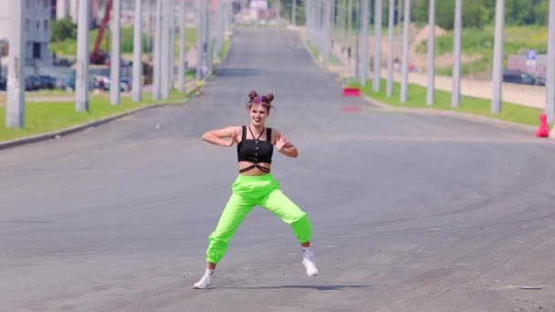 若い精力的な女性が広い都市道路でヒップホップを踊る スローモーション — ストック動画