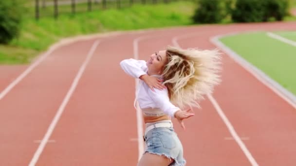 Schöne Junge Blondine Tanzt Auf Dem Laufband Des Stadions Wirkungsvoll — Stockvideo