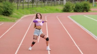Stadyum koşu bandında dans eden genç bir kadının videosu.