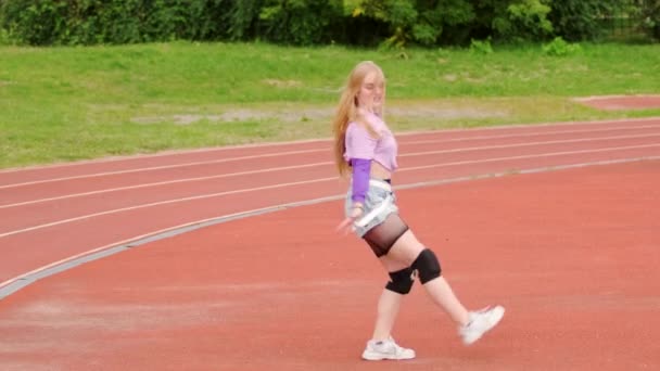 Schöne Junge Blondine Tanzt Auf Dem Laufband Des Stadions Wirkungsvoll — Stockvideo