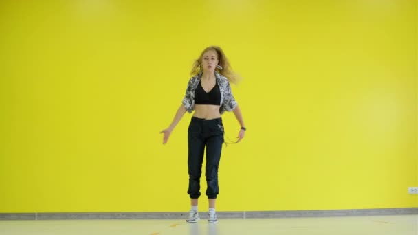 女孩在一面黄色的墙的后面跳嘻哈舞 被隔离了 — 图库视频影像
