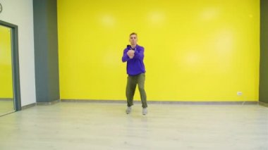 Genç adam hip hop yapıyor, modern gençler serbest dans ediyor stüdyoda..