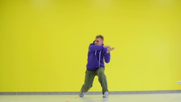 Ten chlap tancuje hip hop, moderní choreografii ve studiu u žluté zdi. Izolované.