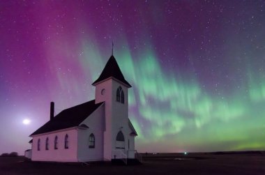 Aurora Borealis Northern Lights over the historic St. John's Lutheran Church established in 1919 near Cabri, Saskatchewan, Canada clipart