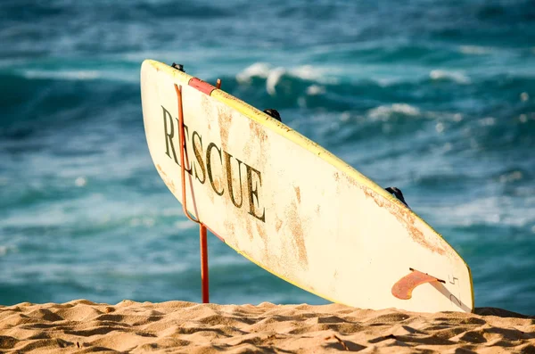 Lifeguards rescue surfboard with waves in the background on Sunset Beach on the north shore of Oahu, Hawaii