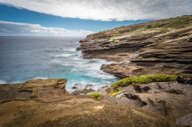 Oahu, Hawaii'deki Lanai Lookout'un eşsiz lav kaya oluşumları etrafında dönen okyanus dalgaları