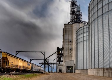 Swift Current, Sk/Canada- 10 Mayıs 2019: Swift Current Paterson Grain Terminali'nde fırtınalı gökyüzü altında yarı boşaltma, Sk, Kanada demiryolu ile