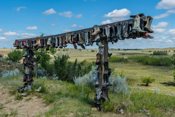 Old cowboy boots hanging on a post in the Great Sandhills in Saskatchewan, Canada