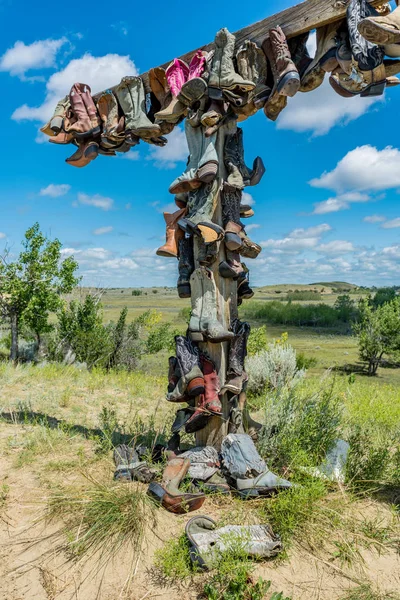 Old cowboy boots hanging on a post in the Great Sandhills in Saskatchewan, Canada