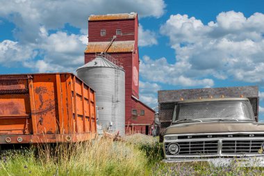 Cadillac, Sk/Kanada- 29 Temmuz 2019: Saskatchewan tarihi Cadillac tahıl asansör, Ön planda iki eski kamyon ile Kanada