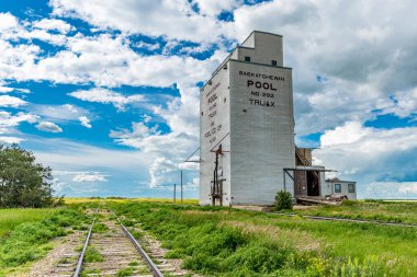 Truax, SK / Kanada - 18 Temmuz 2020 Truax, Saskatchewan 'daki terk edilmiş buğday havuzu tahıl asansörü ve yanında tren rayları.