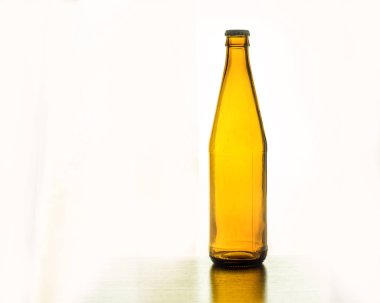 beyaz zemin üzerine masada boş bira şişesi