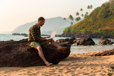 Sahilde koşan adam. Freelancer tatilde. Çalışma ve dinlenme. Eğitim Resort