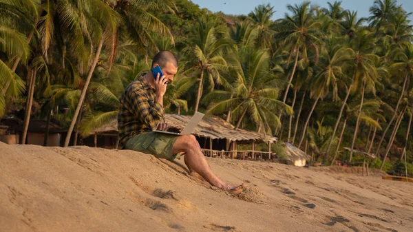 man works on the ocean. Freelancer talking on the phone. Business and leisure, work abroad