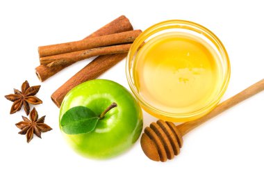 Dilimlenmiş yeşil elmalar, yeşil yapraklar, tarçın, bal ve yıldız anason beyaz arka planda izole edilmiş. en üstteki görünüm