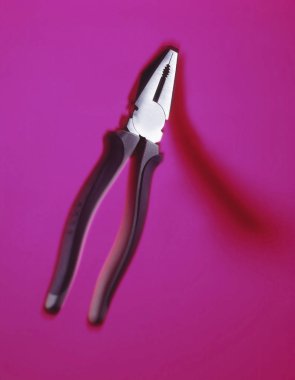 Pembe bir arka plan üzerinde pense