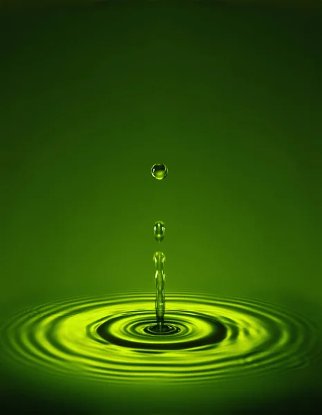 DROPLET WITH RIPPLES IN GREEN LIQUID