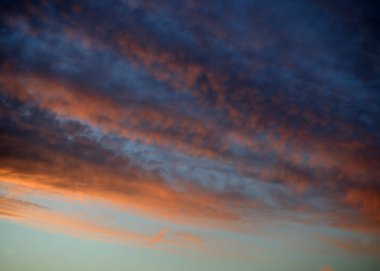 Kırmızı ve turuncu Cirrus ve gün batımında Stratus bulutlar